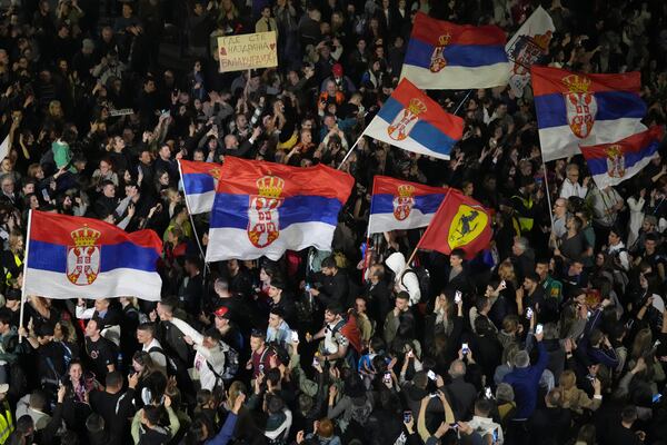 Protesters wave flags ahead of a major rally this weekend in downtown Belgrade, Serbia, Friday, March 14, 2025. (AP Photo/Darko Vojinovic)