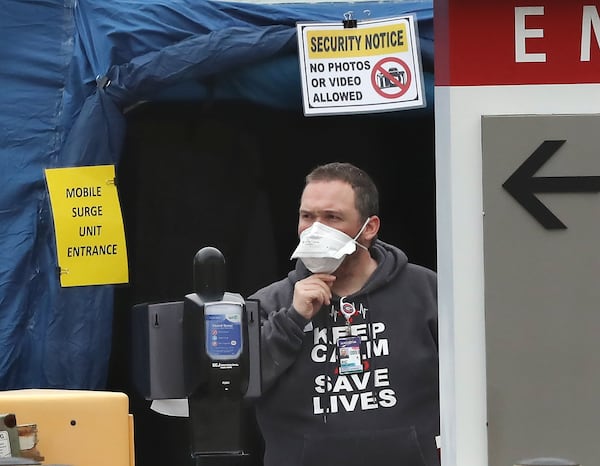 “Keep calm save lives” says the shirt worn by a medical worker at the surge unit at WellStar Kennestone in Marietta. Curtis Compton ccompton@ajc.com