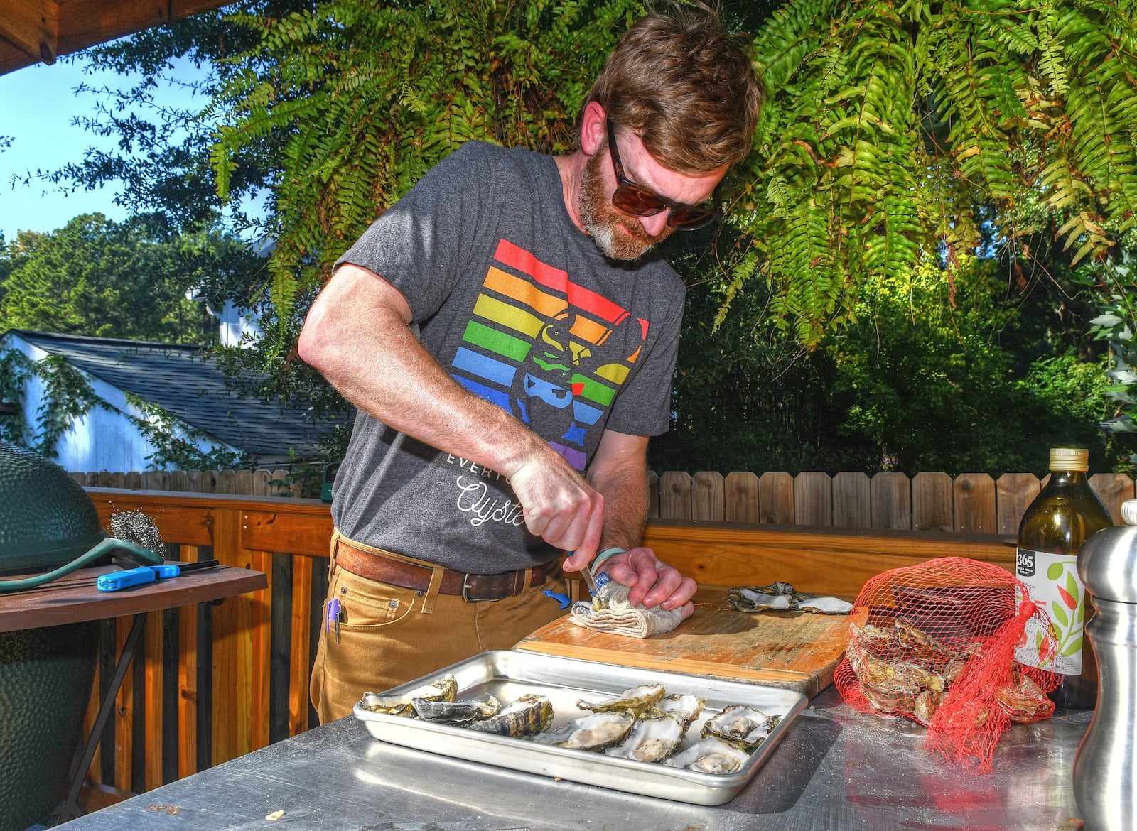 Kimball House's oyster expert Bryan Rackley opens an oyster using a dishcloth on top and bottom to stabilize it while prying it open. Chris Hunt For The AJC