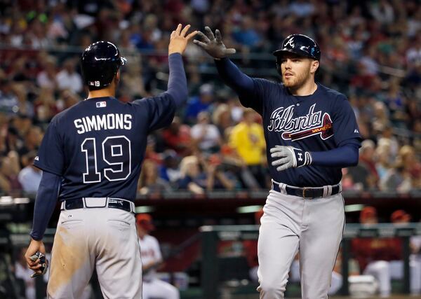 Atlanta Braves' Freddie Freeman high fives Andrelton Simmons (19) after hitting a two-run home run against the Arizona Diamondbacks during the fifth inning of a baseball game, Monday, June 1, 2015, in Phoenix. (AP Photo/Matt York)