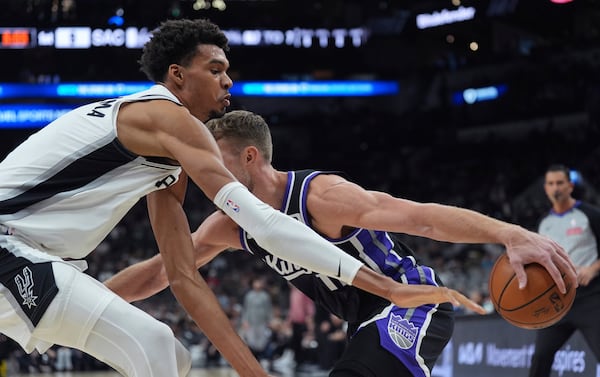 Sacramento Kings forward Domantas Sabonis tries to drive against San Antonio Spurs center Victor Wembanyama during the first half of an NBA basketball game in San Antonio, Monday, Nov. 11, 2024. (AP Photo/Eric Gay)