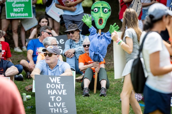 Susanne Fincher (center) holds up her sign before the start of a rally organized by Georgia Moms Demand Action in Piedmont Park Saturday, May 13, 2023. The rally was part of a national series of protests the day before Mother’s Day to highlight the mounting toll of gun violence.  (Steve Schaefer/steve.schaefer@ajc.com)