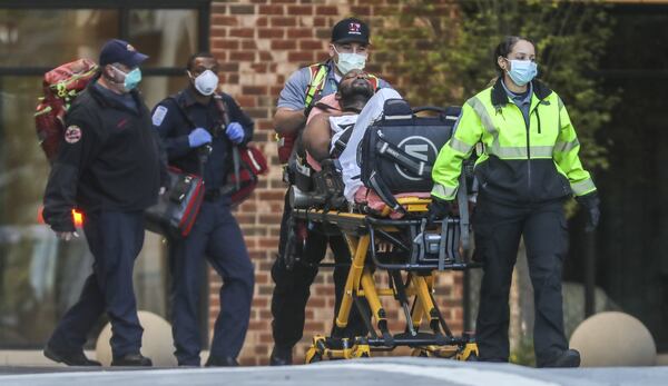 Because of the coronavirus outbreak, Atlanta Fire Rescue paramedics (left) and Grady ambulance crews (right) take extra precautions with gloves and masks during every medical call to which they respond. This call on Wednesday, April 15, 2020, was for a man unconscious in the 900 block of Huff Road at Westside Heights, according to Sgt. Cortez Stafford, public information officer for Atlanta Fire Rescue. JOHN SPINK/JSPINK@AJC.COM