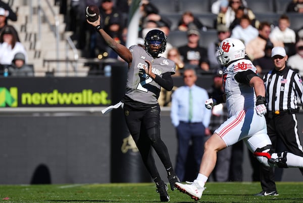 Colorado quarterback Shedeur Sanders, left, throws a pass as Utah defensive tackle Keanu Tanuvasa pursues in the first half of an NCAA college football game Saturday, Nov. 16, 2024, in Boulder, Colo. (AP Photo/David Zalubowski)