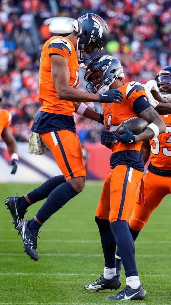 Denver Broncos wide receiver Troy Franklin, right, celebrates his touchdown with wide receiver Devaughn Vele (17) during the second half of an NFL football game against the Atlanta Falcons, Sunday, Nov. 17, 2024, in Denver. (AP Photo/Jack Dempsey)