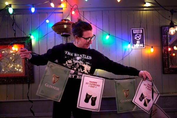 Bartender Michelle Flynn strings up St. Patrick's Day decorations at the Irish pub Brendan Behan, Wednesday, March 12, 2025, in Boston. (AP Photo/Robert F. Bukaty)