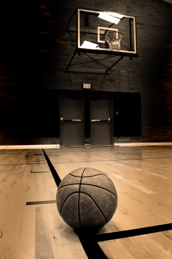 Basketball on court with hoop in the background ** Note: Shallow depth of field