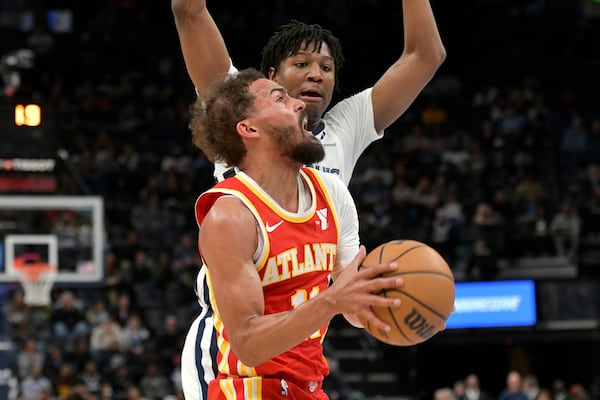 Atlanta Hawks guard Trae Young, front, drives ahead of Memphis Grizzlies forward GG Jackson II, back, in the first half of an NBA basketball game Monday, March 3, 2025, in Memphis, Tenn. (AP Photo/Brandon Dill)