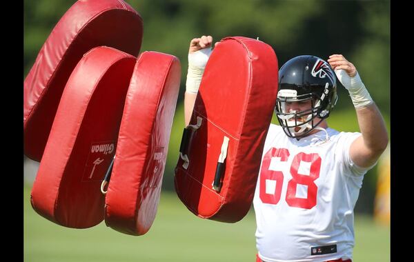 073115 FLOWERY BRANCH: Falcons guard Mike Person tosses out some pads for drills on the first day of training camp on Friday, July 31, 2015, in Flowery Branch. Curtis Compton / ccompton@ajc.com