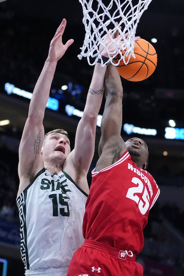 Wisconsin guard John Blackwell (25) and Michigan State center Carson Cooper (15) reach for a rebound during the first half of an NCAA college basketball game in the semifinals of the Big Ten Conference tournament in Indianapolis, Saturday, March 15, 2025. (AP Photo/Michael Conroy)