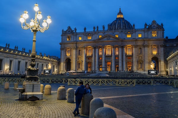 A couple stands in St. Peter's Square at The Vatican, Monday, Feb. 24, 2025. (AP Photo/Bernat Armangue)