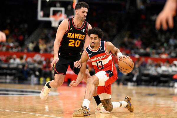 Washington Wizards guard Jordan Poole (13) dribbles against Atlanta Hawks forward Georges Niang (20) during the first half of an NBA basketball game, Saturday, Feb. 8, 2025, in Washington. (AP Photo/Nick Wass)