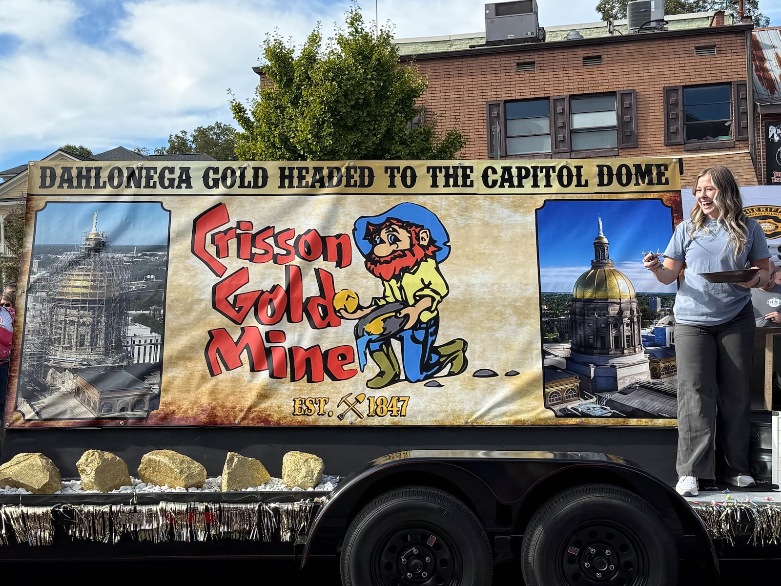 Brianna Ray Weaver, one of the owners of Crission Gold Mine, stands aboard the mine's float in the 70th annual Gold Rush Days festival parade on Oct. 19, 2024.