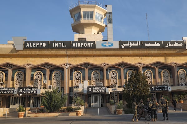 Syrian opposition fighters stand at the entrance of the Aleppo international airpot in Aleppo, Syria, Monday, Dec. 2, 2024. .(AP Photo/Omar Albam)