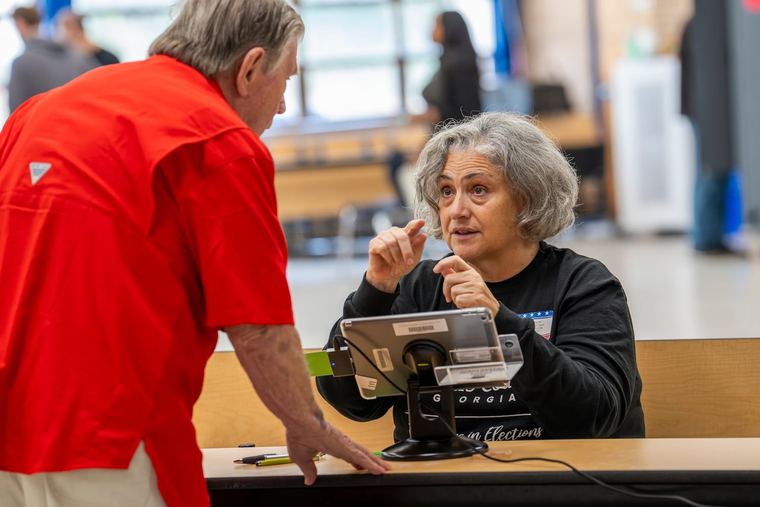 A poll worker, who declined to be named for fear of post-election violence, helps an elderly man prepare to vote at a polling site in Chamblee on election day  Tuesday, Nov. 5, 2024. (Olivia Bowdoin for the AJC). 