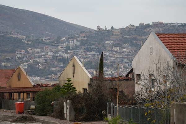 Backdropped by the southern Lebanon town of Kfar Kila, houses damaged by Hezbollah rockets attacks are seen in Metula, Israel's northernmost town, Wednesday Dec. 4, 2024. 2024. (AP Photo/Ohad Zwigenberg)