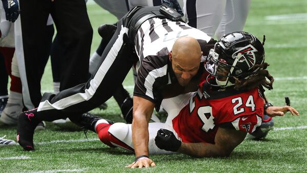 An official takes down Falcons running back Devonta Freeman to end a fight between Falcons and Rams players in the second half Sunday, Oct. 20, 2019, at Mercedes-Benz Stadium in Atlanta. Freeman was ejected from the game.