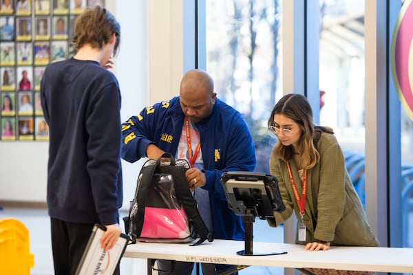 Staff members Jamie Walker (left) and Marlene Salgado Benitez (right) search a student's backpack at Maynard Jackson High School in Atlanta on Tuesday, January 10, 2023. Atlanta Public Schools have implemented a new weapons detection system called "Evolv" in their middle and high schools. CHRISTINA MATACOTTA FOR THE ATLANTA JOURNAL-CONSTITUTION.