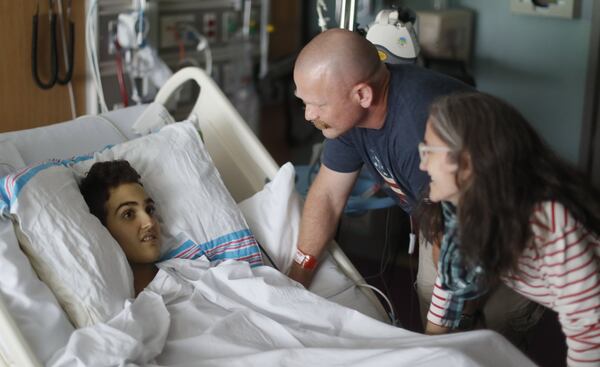 May 30, 2019 - Atlanta - Logan Droke and his father, Randall, and stepmother, Veronique, spend some time together in his hospital room. Logan, 18, from Canton, facing his fourth battle with leukemia at Children’s Healthcare of Atlanta at Scottish Rite, is set to graduate from Creekview High School on Friday. Firefighters in two departments are rallying behind the teenager by raising money to help pay for treatments. Bob Andres / bandres@ajc.com