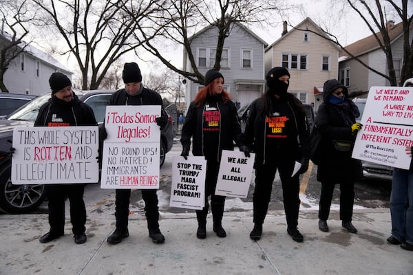 FILE - Activists with Revcom Corps Chicago hold signs outside of Hamline Elementary School after federal agents were turned away on Jan. 24, 2025, in Chicago. (AP Photo/Erin Hooley, file)