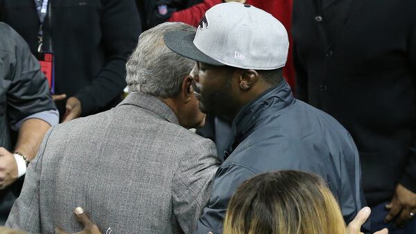 Former Falcons quarterback Michael Vick and owner Arthur Blank hug on the sideline before the Falcons play the Saints on Sunday, Jan. 1, 2017, in Atlanta. 