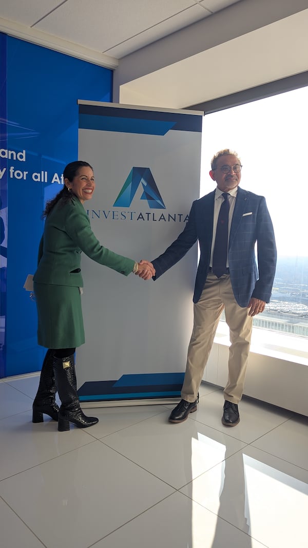 Invest Atlanta President and CEO Eloisa Klementich (left) and Savi Provisions CEO Paul Nair shake hands in the Invest Atlanta office on Thursday, Dec. 19, 2024, after officials approved nearly $8.2 million in incentives for two Savi-operated grocery stores. (Mirtha Donastorg/AJC)