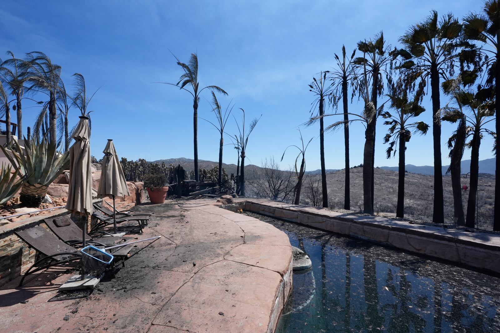 A fire-ravaged property is seen after the Airport Fire swept through Wednesday, Sept. 11, 2024, in El Cariso Village, in unincorporated Riverside, County, Calif. (AP Photo/Gregory Bull)