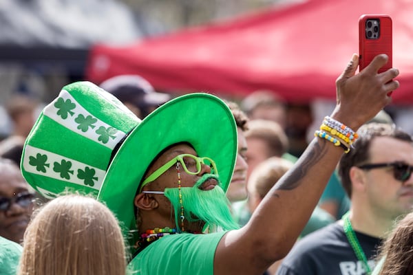 A spectator dressed in his finest St. Patrick's day outfit uses his cell phone to record part of the 200th anniversary celebration of Savannah's first St. Patrick's Day parade on March 16, 2024, in Savannah, Ga. Georgia's oldest city first parade started with a modest procession on March 17, 1824. (AJC Photo/Stephen B. Morton)