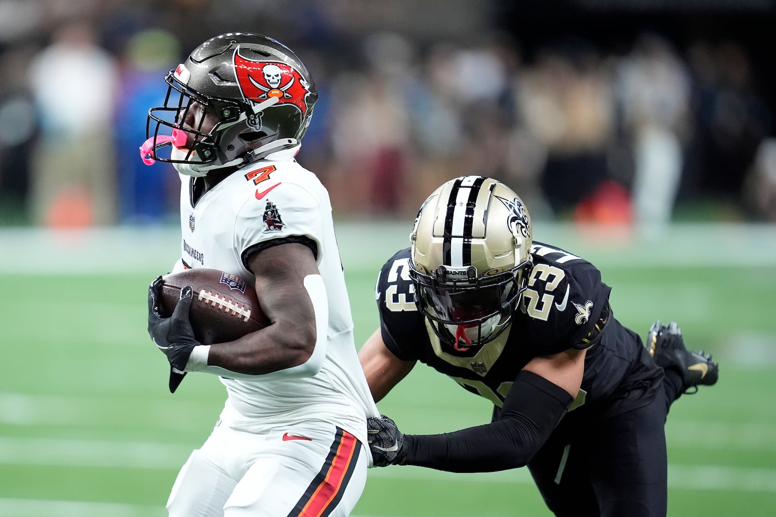 Tampa Bay Buccaneers running back Bucky Irving (7) runs against New Orleans Saints cornerback Marshon Lattimore (23) during the first half of an NFL football game in New Orleans, Sunday, Oct. 13, 2024. (AP Photo/Michael Conroy)