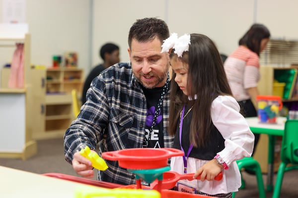 Duluth Middle School teacher Jeff Mraz plays with a child at the Play 2 Learn program at Duluth Middle School, Wednesday, Nov. 8, 2023, in Duluth. Mraz teaches the Teaching as a Profession class. The students Mraz teaches are part of the teaching profession program and have an interest in a career in education. (Jason Getz / Jason.Getz@ajc.com)