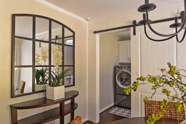 The breakfast room leads to the laundry along a shiplap wall and barn door — both which were added during the $250,000 worth of renovations over the course of four months. Tracy Davis from Creative Closets designed the laundry space, which has Electrolux appliances and a gray rug from Target. The black mirror is from Ballard Designs while the wood demilune console table is from Crate & Barrel. Text by Marena Galluccio/Fast Copy News Service. (Christopher Oquendo/www.ophotography.com)