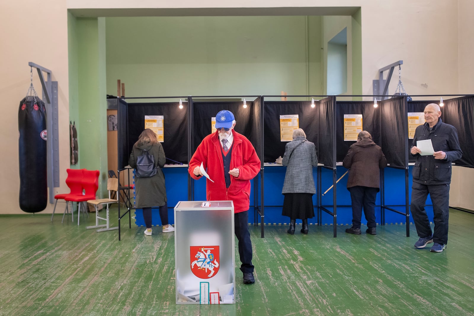 Local residents vote at a polling station during the first round of voting in a parliamentary election, in Vilnius, Lithuania, Sunday, Oct. 13, 2024. (AP Photo/Mindaugas Kulbis)