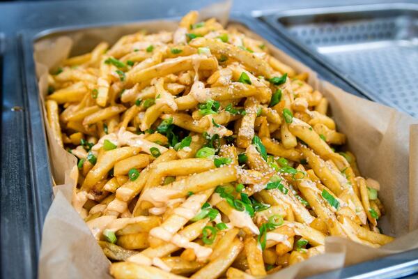 French fries fresh from the fryer, sprinkled with chives, sesame seeds and spicy mayo. CONTRIBUTED BY HENRI HOLLIS