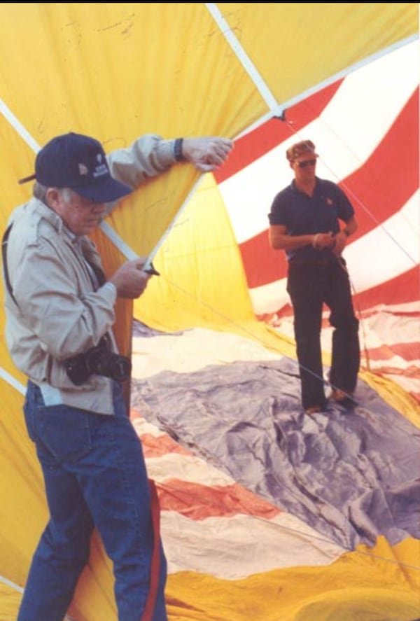 Jimmy Carter holds the "throat" of the balloon as Neal Boortz gets his contraption ready to fly.