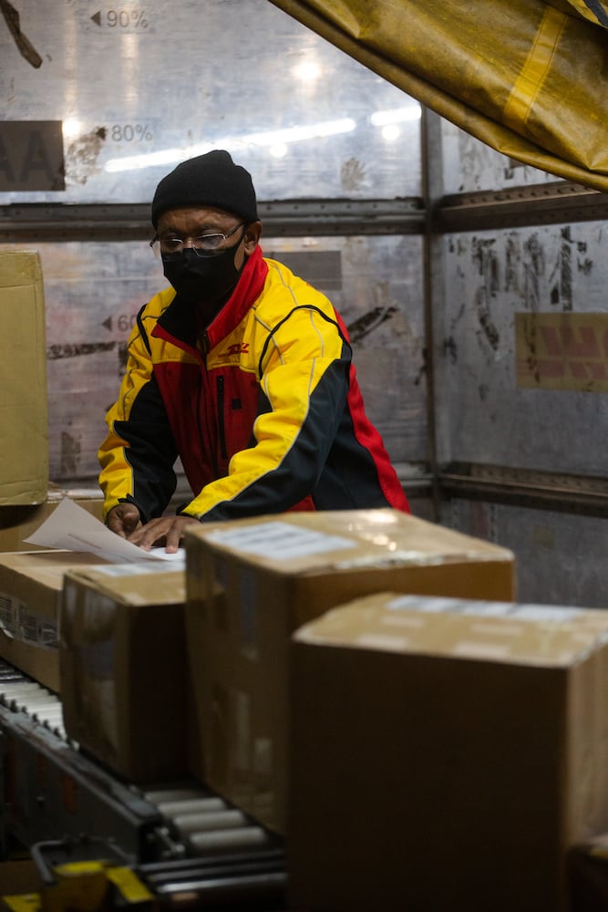 Willie Gurerra sorts packages on Wednesday, December 16, 2020, at DHL Express in Atlanta. Workers at the shipping center worked to fulfill orders during the holiday rush. CHRISTINA MATACOTTA FOR THE ATLANTA JOURNAL-CONSTITUTION.