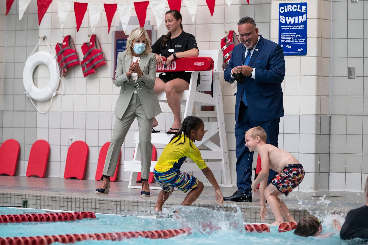 First Lady Jill Biden and Education Secretary Miguel Cardona cheer as students climb out of and jump into a swimming pool while they visit a Horizons Atlanta summer learning program at the University of Georgia in Athens, Georgia on Thursday, July 21, 2022. The program serves students from Barnett Shoals Elementary School. (Chris Day/Christopher.Day@ajc.com)