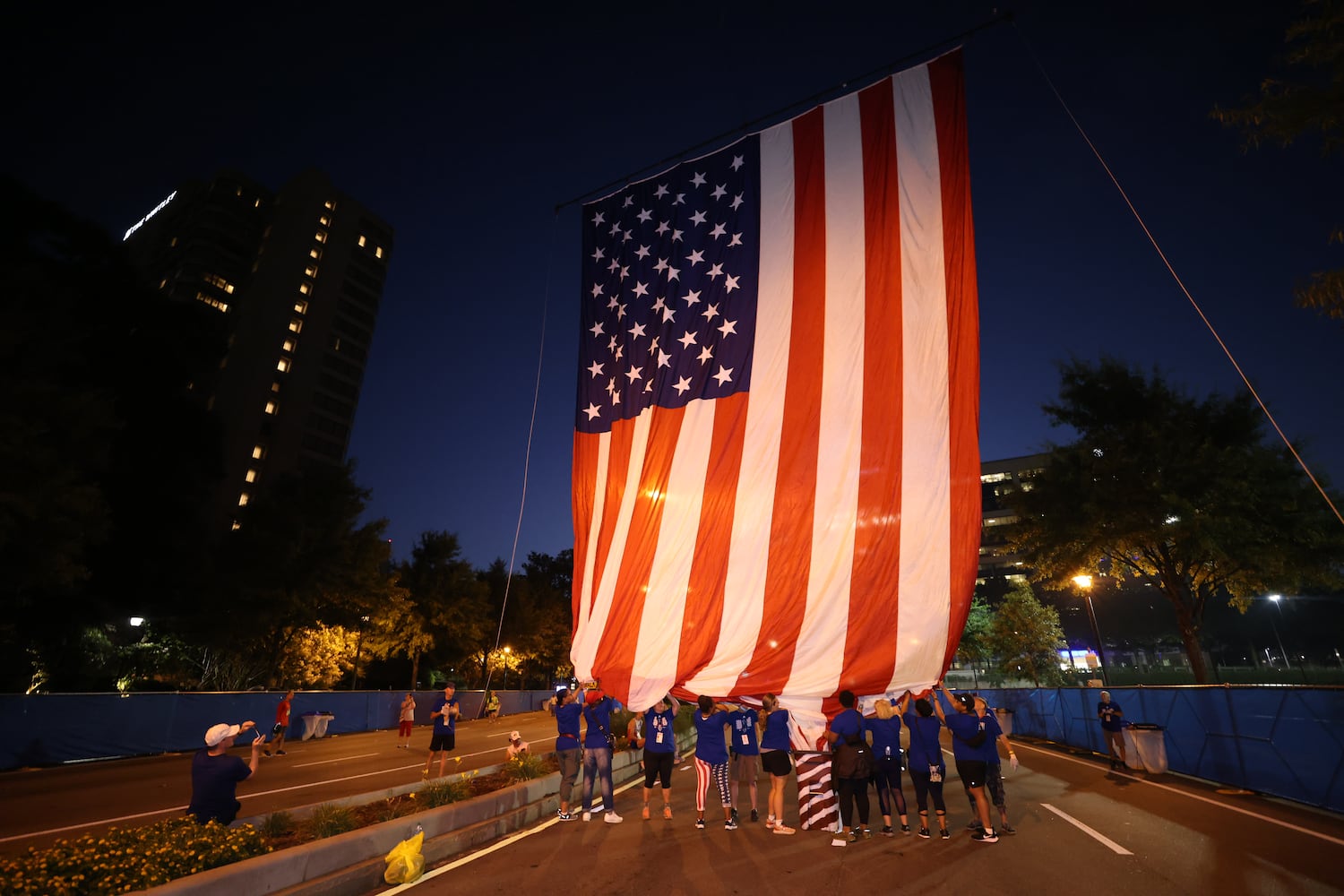 A giant American flag is raised over the staring line of the 53rd running of the Atlanta Journal-Constitution Peachtree Road Race in Atlanta on Monday, July 4, 2022. (Jason Getz / Jason.Getz@ajc.com)