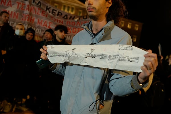 A protester takes part in a rally, after the Greek opposition parties have challenged the country's center-right government with a censure motion in parliament over a devastating rail disaster nearly two years ago, in Athens, Wednesday, March 5, 2025. (AP Photo/Petros Giannakouris)