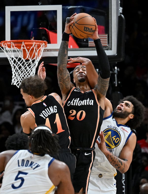 Atlanta Hawks' forward John Collins (20) grabs the rebound over Golden State Warriors' forward Anthony Lamb (40) during the second half in an NBA basketball game at State Farm Arena, Friday, March 17, 2023, in Atlanta. Atlanta Hawks won 123-119 over Golden State Warriors. (Hyosub Shin / Hyosub.Shin@ajc.com)