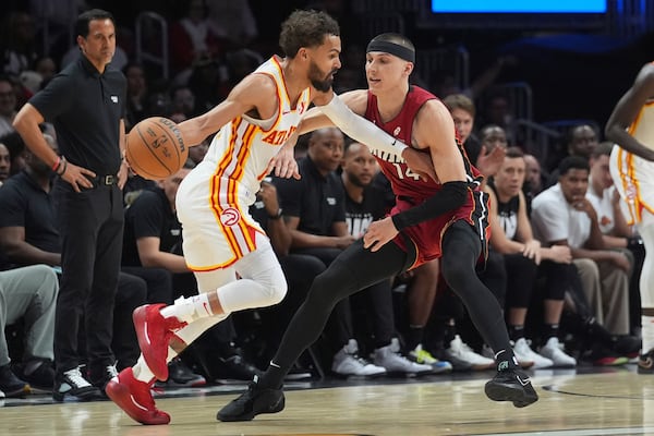 Hawks star Trae Young fends off the Heat's Tyler Herro during Wednesday's game in Miami.