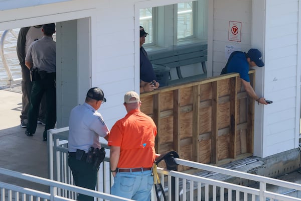 Investigators from a private entity, WJA, are seen taking photos on the pier after a gangway collapsed Saturday, killing seven people and critically injuring three more on Sapelo Island. WJE has investigated virtually every major structural collapse in the United States over the past five decades. (Miguel Martinez / AJC)