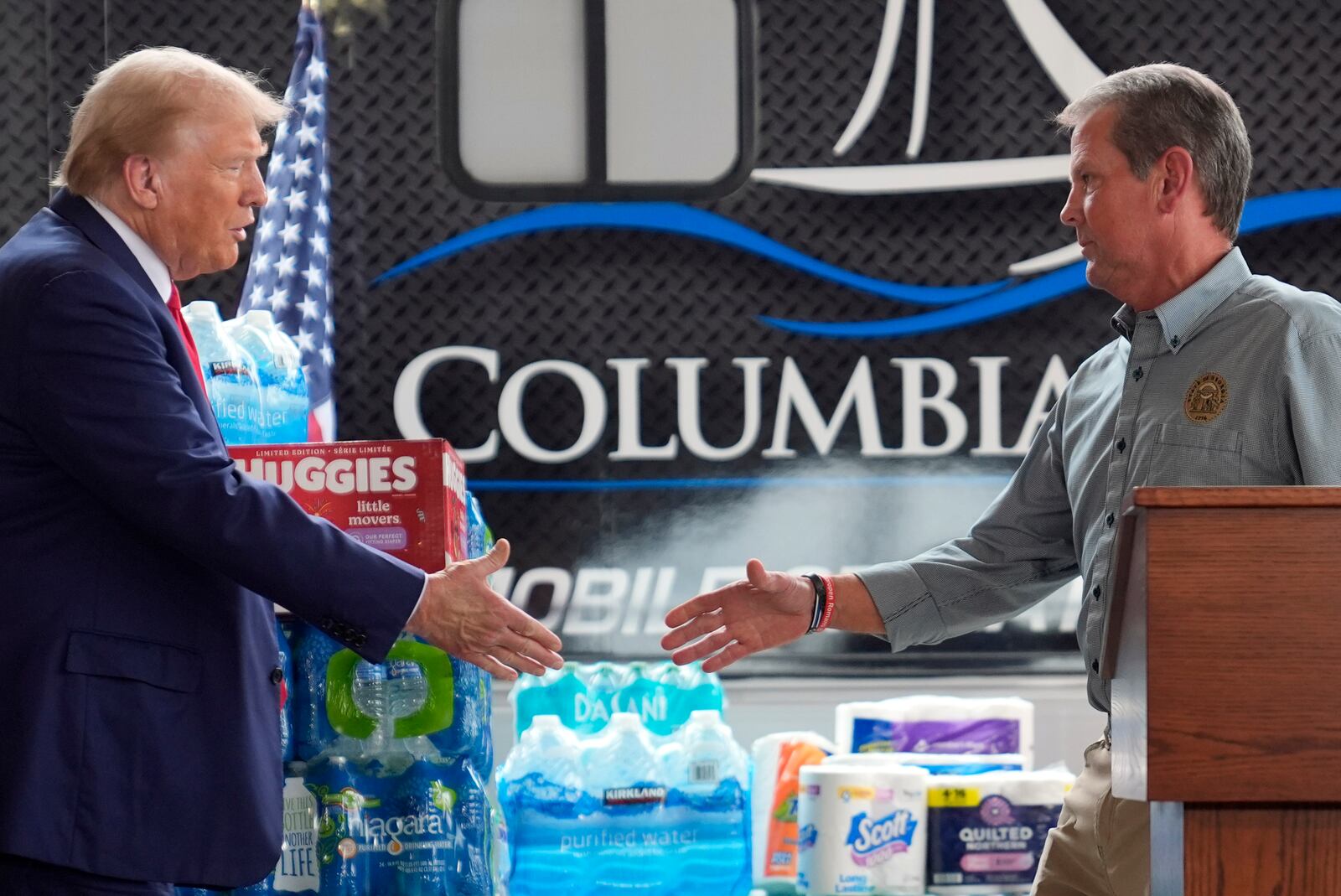 Republican presidential nominee former President Donald Trump shakes hands with Georgia Gov. Brian Kemp at a temporary relief shelter as he visits areas impacted by Hurricane Helene, Friday, Oct. 4, 2024, in Evans, Ga. (AP Photo/Evan Vucci)