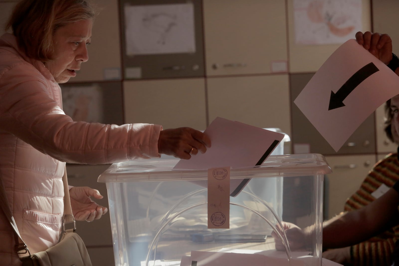 A woman holds his ballot at a polling station during the general elections in Sofia, Sunday, Oct. 27, 2024. (AP Photo/Valentina Petrova)