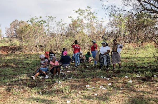 Relatives of miners and community members wait at a mine shaft where an estimated 4000 illegal miners are trapped in a disused mine in Stilfontein, South Africa, Wednesday, Nov.13, 2024. (AP Photo)