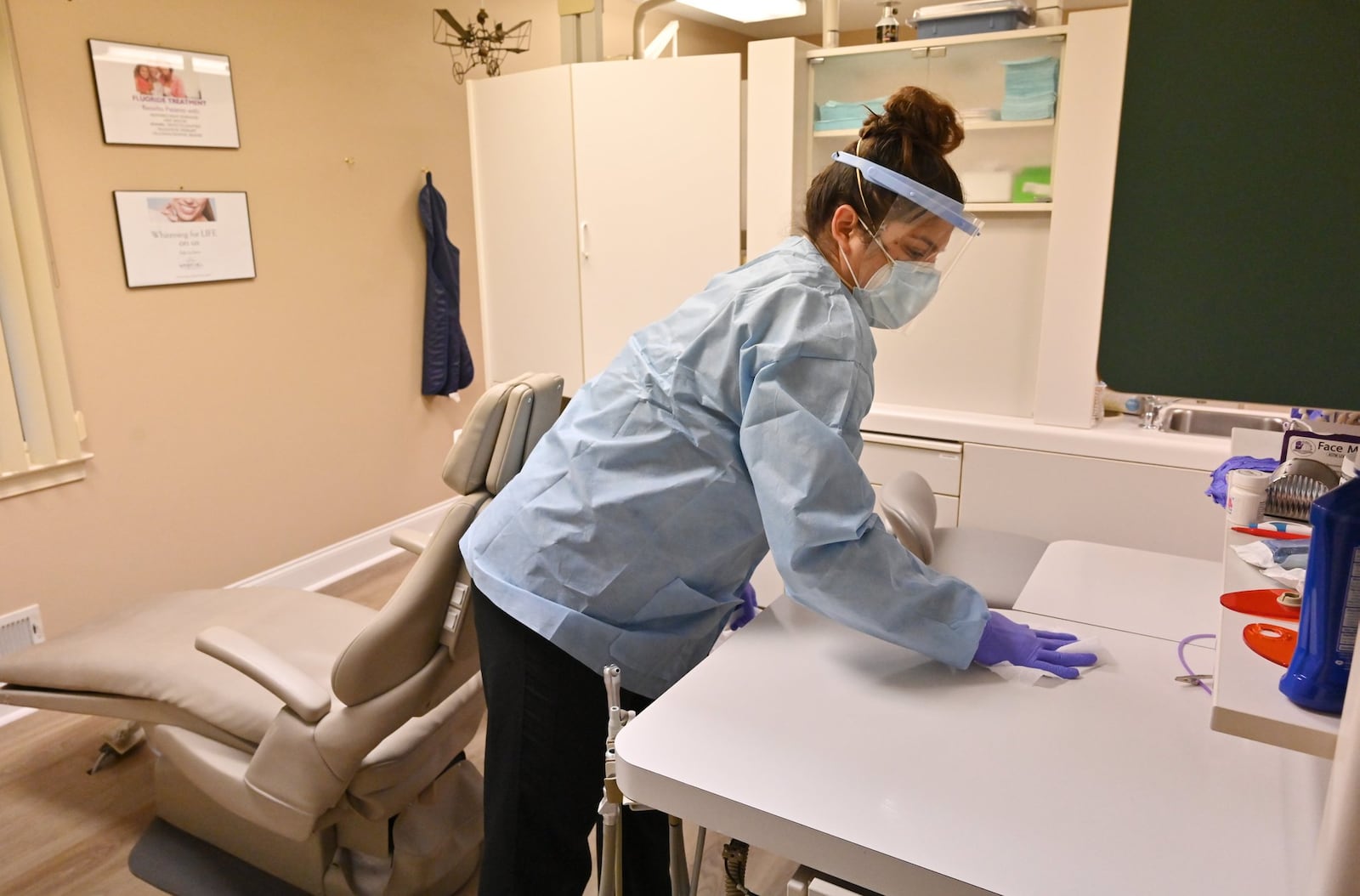 In this file photo, Adriana Sarti, an assistant at Windy Hill Dentistry, uses a disinfectant wipe to sanitize the treatment room after a patient left. While dentists for decades have worn masks and gloves when treating patients, the coronavirus pandemic has led to even stricter infection-control measures. (Hyosub Shin / Hyosub.Shin@ajc.com)