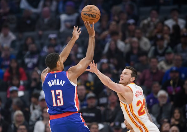 Sacramento Kings forward Keegan Murray (13) shoots over Atlanta Hawks guard Garrison Mathews during the first half of an NBA basketball game in Sacramento, Calif., Monday, Nov. 18, 2024. (AP Photo/Randall Benton)