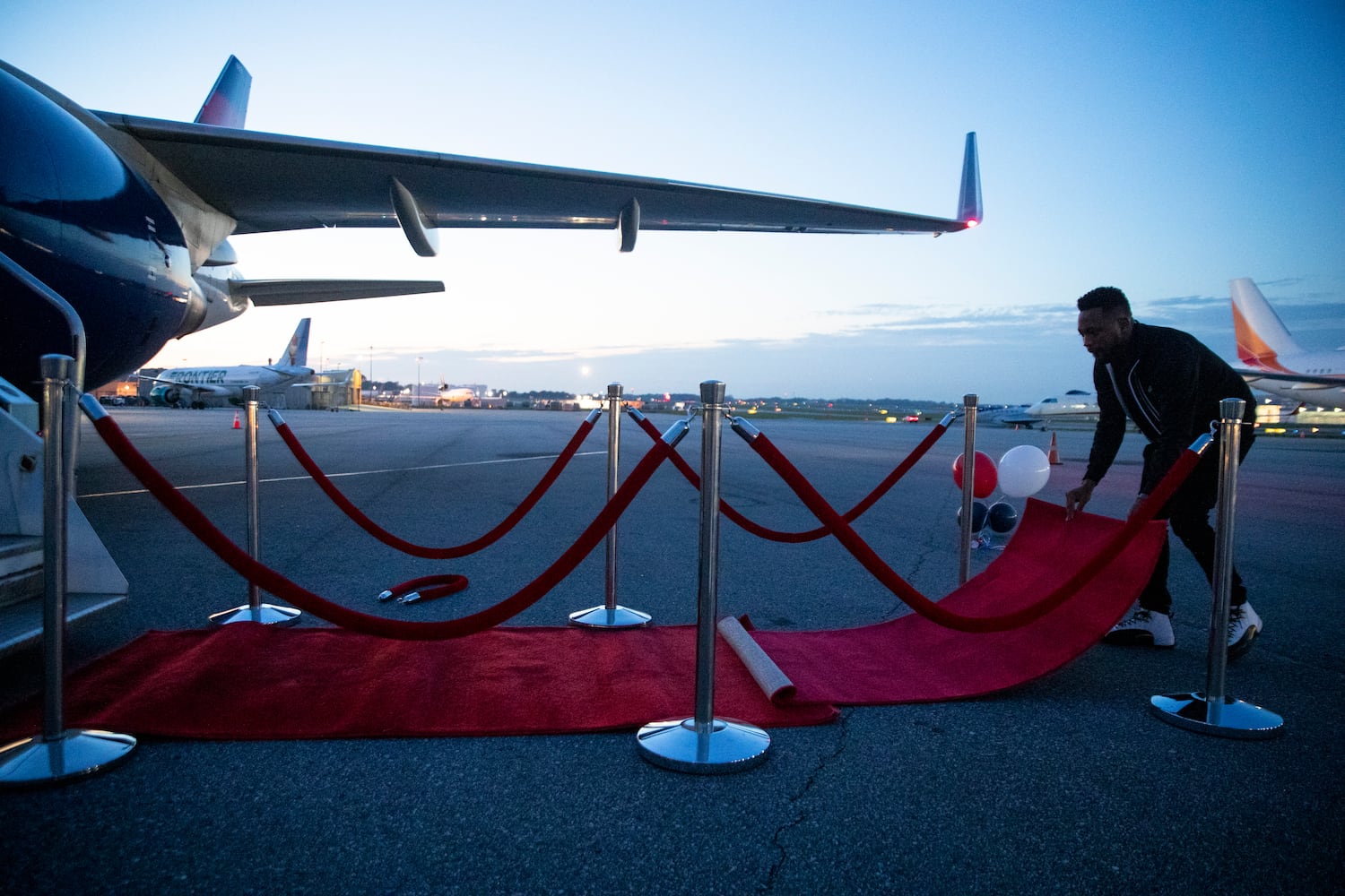 Jamar Harrison, president of the Black employee resource group at Delta Airlines, lays out a red carpet for participants of Delta’s Dream Flight 2022 at Hartsfield-Jackson Atlanta International Airport on Friday, July 15, 2022. Around 150 students ranging from 13 to 18 years old will fly from Atlanta to the Duluth Air National Guard Base in Duluth, Minnesota.(Chris Day/Christopher.Day@ajc.com)