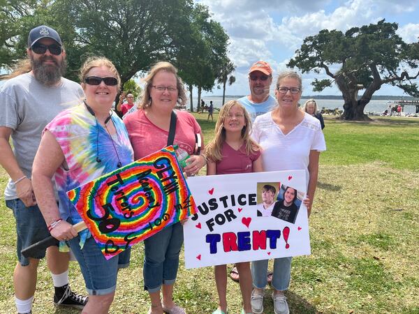 11-year-old Madelynn Grissom stands with her family while holding a poster she made for the rally.