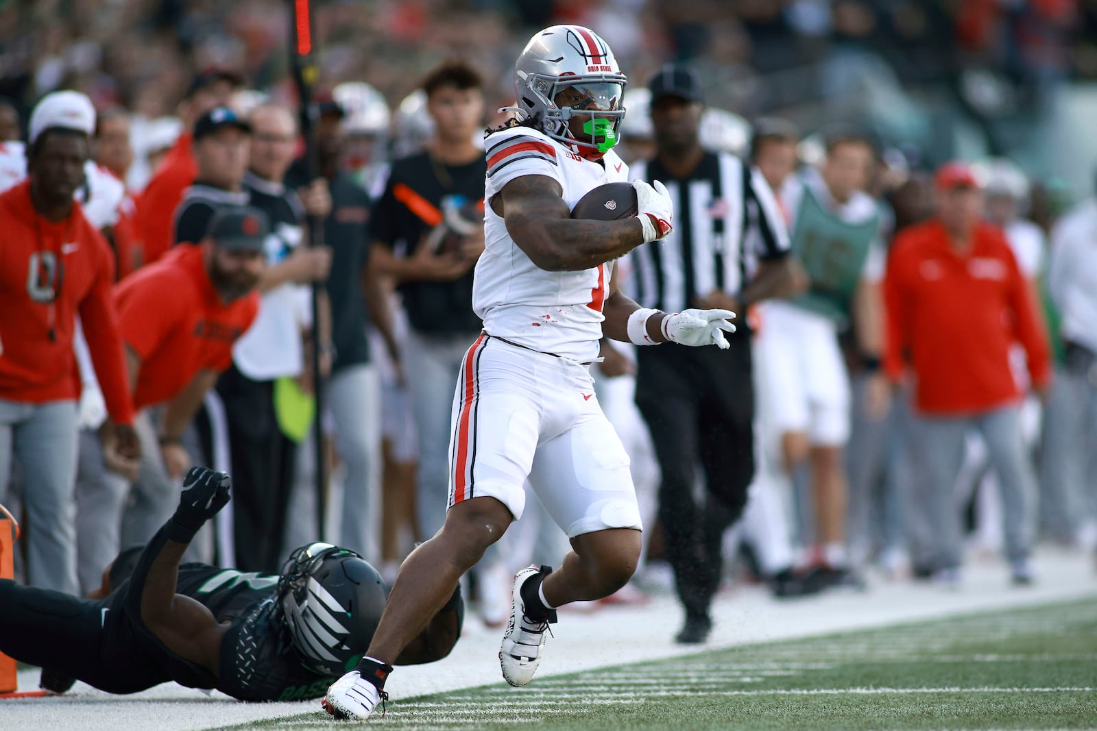 Ohio State running back Quinshon Judkins, right, dodges a tackle during an NCAA college football game against Oregon, Saturday, Oct. 12, 2024, in Eugene, Ore. (AP Photo/Lydia Ely)