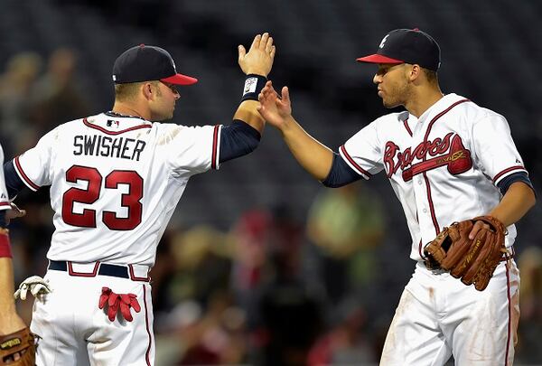 Atlanta Braves left fielder Nick Swisher (23) celebrates with shortstop Andrelton Simmons after defeating the Washington Nationals 2-0 in a baseball game Wednesday, Sept. 30, 2015, in Atlanta. (AP Photo/Jon Barash)